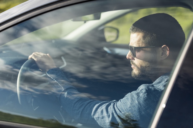 male-with-sunglasses-driving-car_23-2148181488